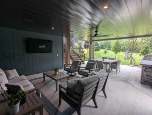 A spacious finished patio ceiling with a fan, recessed lighting, and outdoor furniture by Dry Deck Ceilings KC in Kansas City, KS.