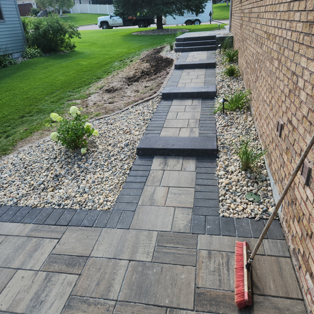 Ground-level view of a finished paver walkway and steps by Great Plains Remodeling and Handyman Services in Mitchell, SD.