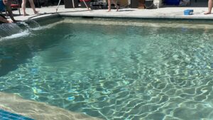 A finished swimming pool and patio area with clear water by 5 Daughters Total Outdoors in Austin, TX.