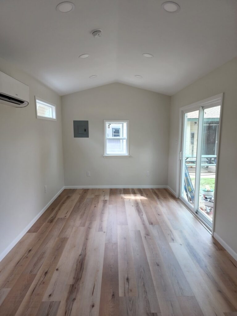 A finished renovated room featuring new flooring, white walls, and recessed lighting by Burleson De Lago Real Hardwood Floors in Austin, TX.