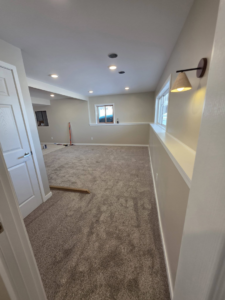 A finished room with new carpet, recessed lighting, and a wall sconce by Rosenthal Remodeling in Milton, WI.