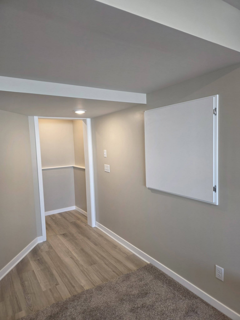 A finished room featuring new flooring, recessed lighting, and trim work by Rosenthal Remodeling in Milton, WI.