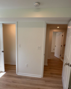 A finished room featuring new light wood flooring and fresh paint, completed by Under The Wire Renovations in Atlanta, GA.