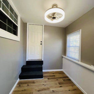 A beautifully finished room renovation with new flooring, fresh paint, and a modern light fixture by A 2 Z Home Services - Fairmont WV.