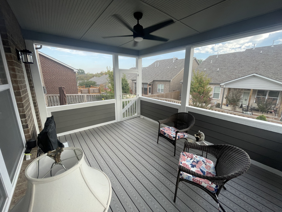 A beautifully finished screened-in porch with composite decking and a ceiling fan by Music City Home Experience in Nashville, TN.