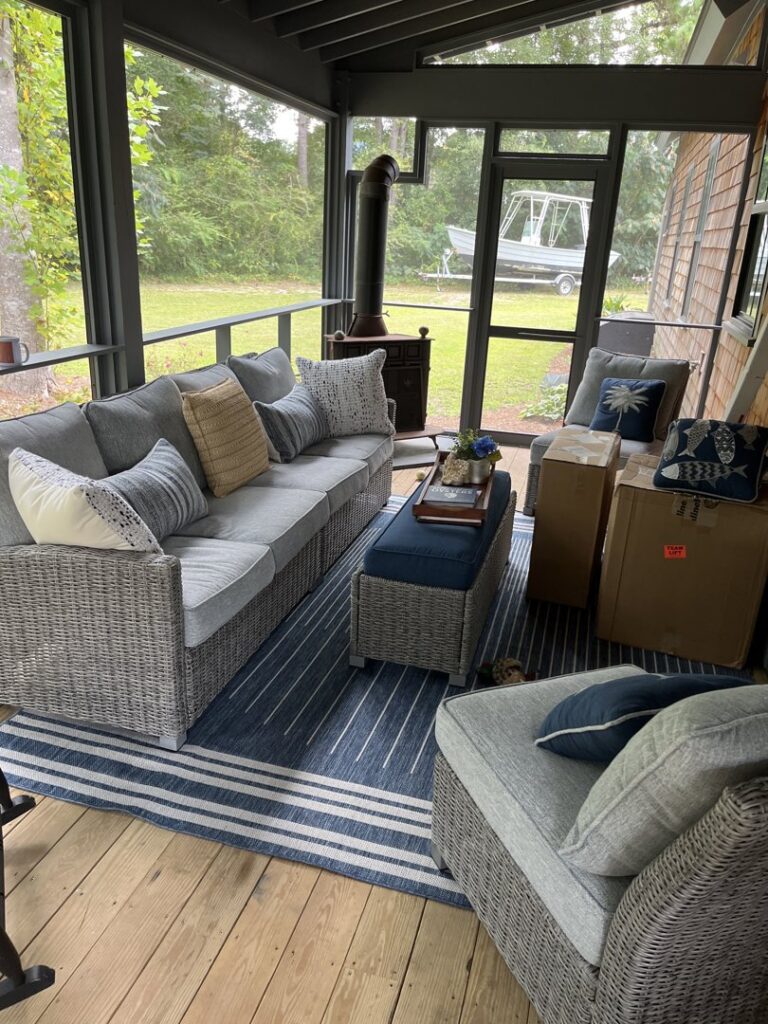 A beautifully finished screened porch with comfortable outdoor furniture by Seaside Craftworks LLC in Wilmington, NC.
