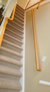A finished staircase with a newly installed wooden handrail by Small Jobs Well Done in Avon, CT.
