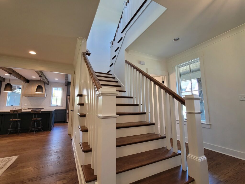 A beautifully finished staircase with white risers and dark wood treads by Painting Pros of Knoxville in Knoxville, TN.