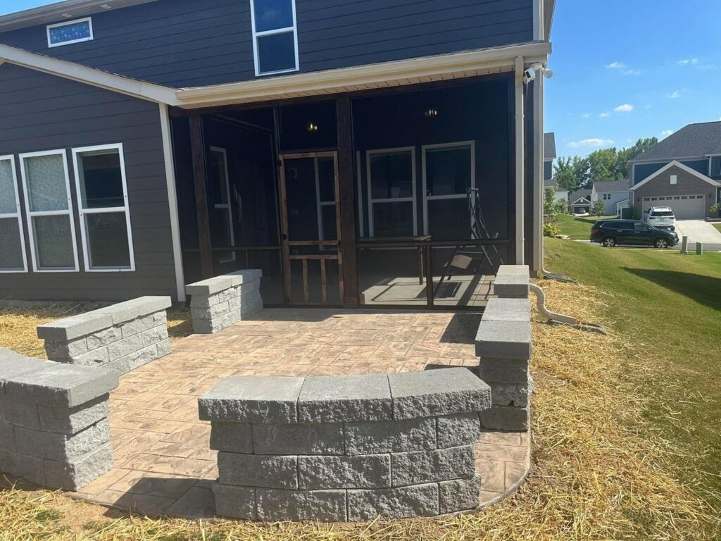 Finished stamped concrete patio with integrated retaining walls by Solid Rock Builders in Rock Hill, SC.