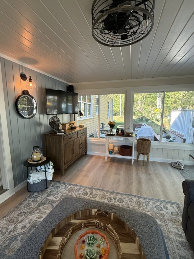 Beautifully finished sunroom remodel with new flooring, wall paneling, and a modern ceiling fan by Byrd's Contracting, LLC in Bristol, CT.