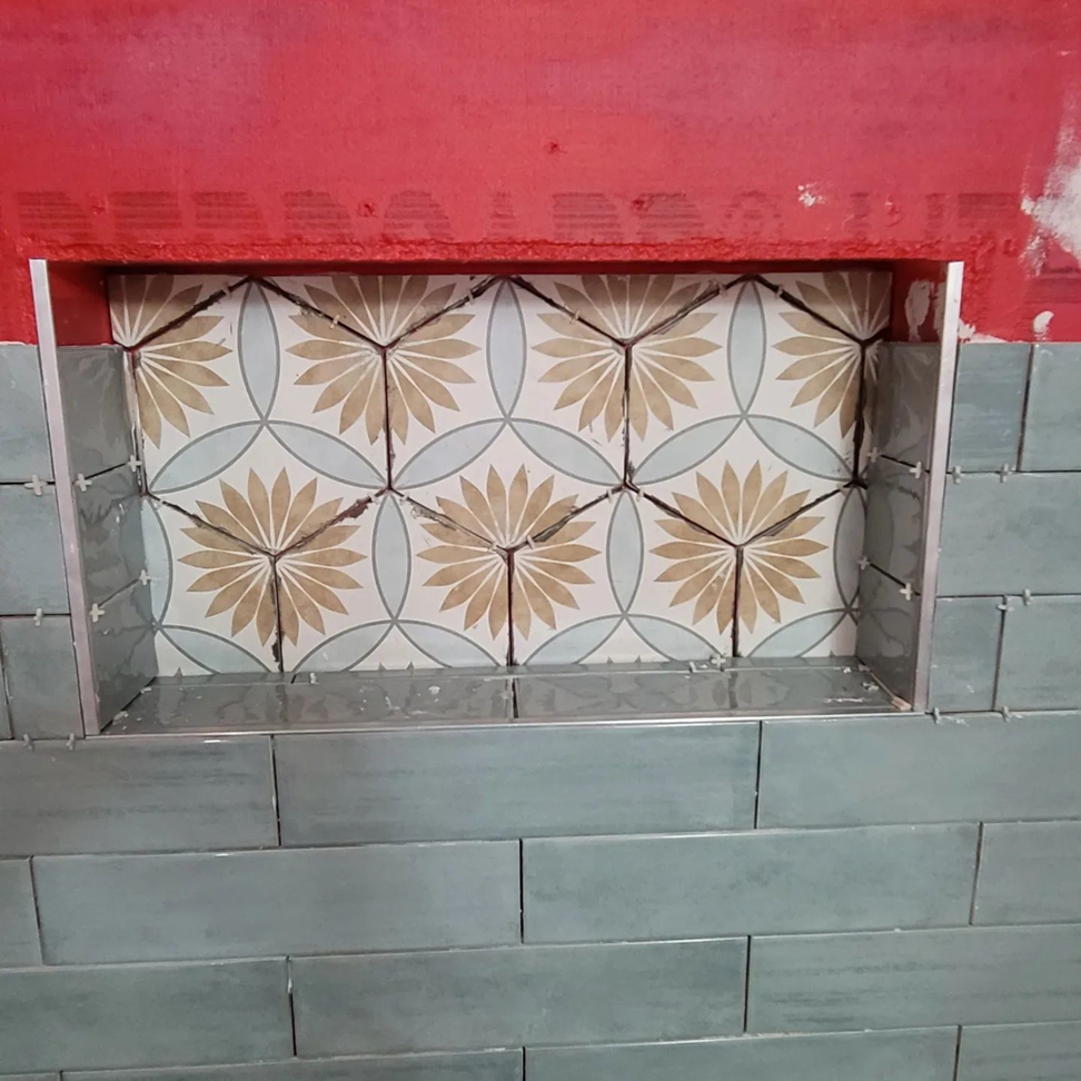 A close-up of a beautifully finished tiled shower niche with decorative patterns by Tier 1 Contracting Inc. in Apache Junction, AZ.