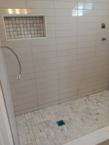 A newly finished tiled shower with a built-in niche, showcasing work by Juancho's Handyman in Salida, CO.