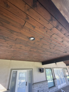 A beautifully finished wooden plank ceiling with recessed lighting on an outdoor patio by Javier's Painting in San Angelo, TX.