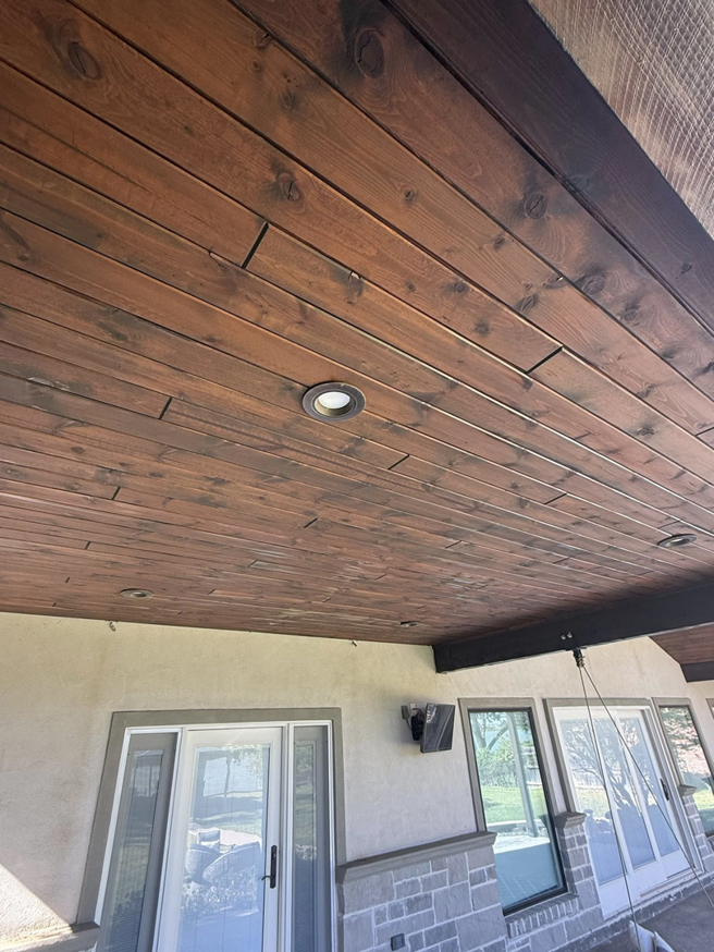 A beautifully finished wooden plank ceiling with recessed lighting on an outdoor patio by Javier's Painting in San Angelo, TX.