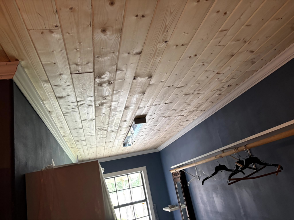 Finished wood plank ceiling installation with crown molding by Verkler Development LLC in Lake Charles, LA.