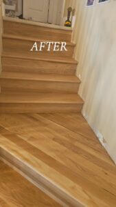 Newly finished wood stairs and adjacent flooring after a refinishing project by Quick Sand Flooring & Install LLC in Millcreek, UT.
