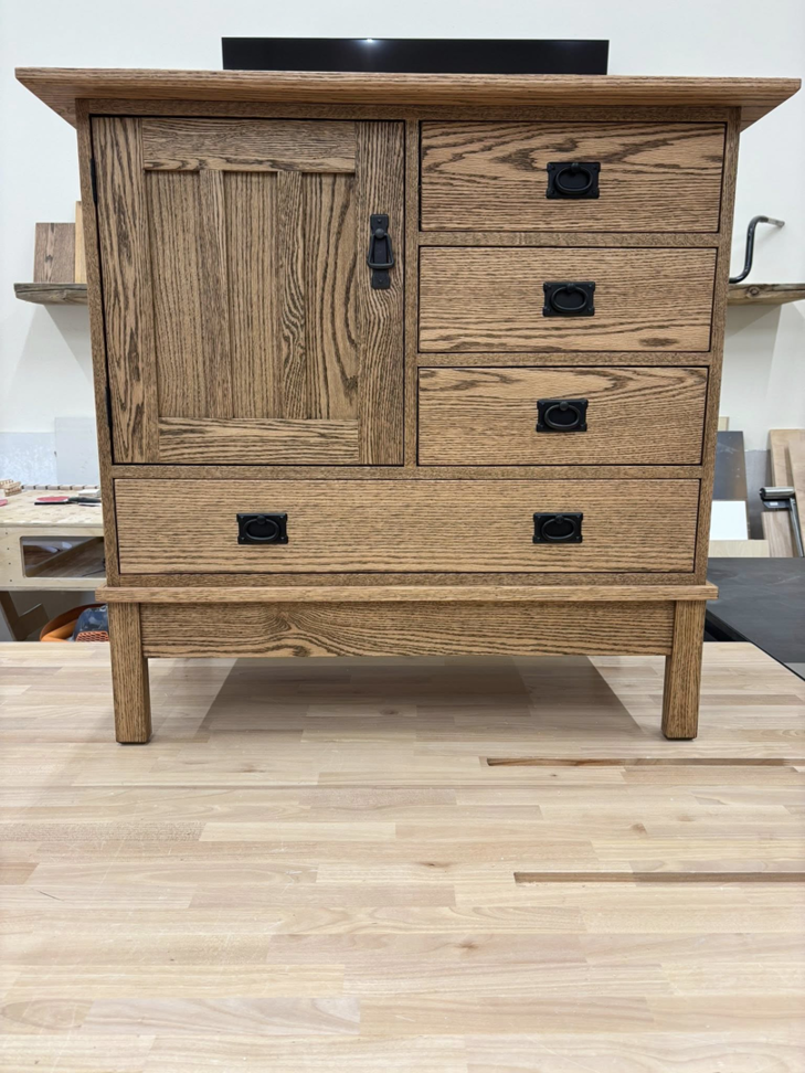 A beautifully finished wooden cabinet or dresser with multiple drawers and a door, crafted by Kingsbury Builders LLC in Janesville, WI