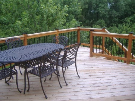 Finished wooden deck with outdoor dining furniture, built by Tschida Construction in Cologne, MN.