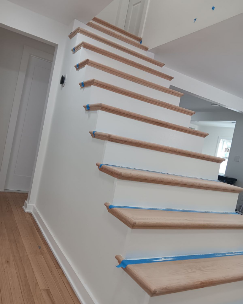Newly installed wooden staircase with white risers by Spotless & Handyman, LLC in Brockton, MA.