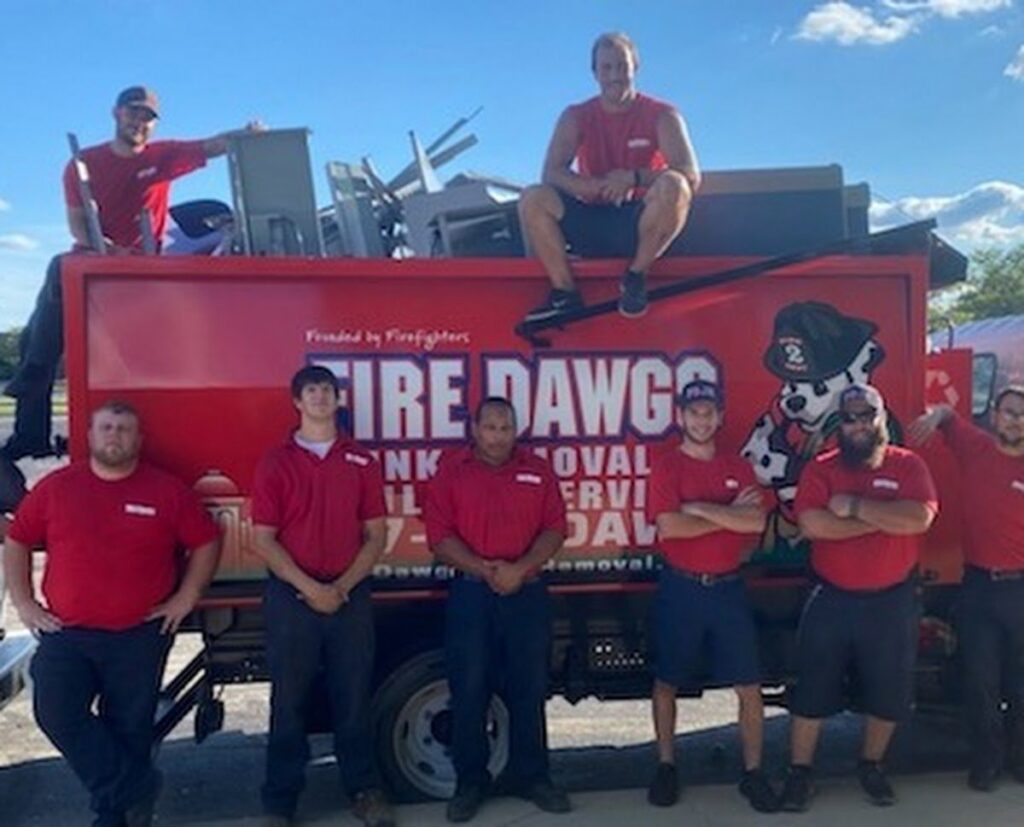 The Fire Dawgs Junk Removal team stands proudly in front of their truck filled with removed items in Bloomington, IN.