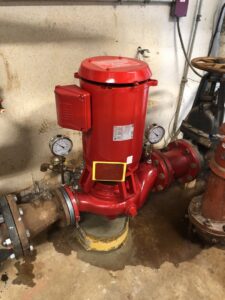 A red fire pump system with gauges and piping, maintained by Absolute Fire Sprinklers in Bristol, CT.