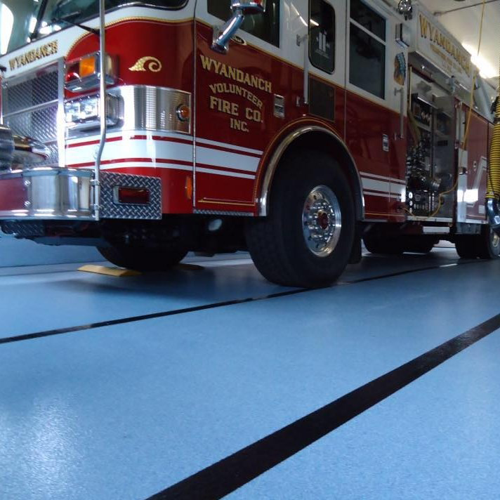 A durable blue epoxy floor with black lines installed in a fire station by Blendex Industrial Epoxy Floors in Lindenhurst, NY