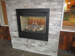 A modern fireplace featuring a light brick surround installed by Qual-i-Tee bilt homes - Steve Johnson in Salem, OR.