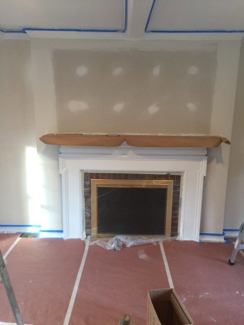 Fireplace area with drywall and plaster repair in progress by Farnsworth Interiors Drywall and Plaster in Akron, OH