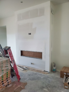Fireplace framing and drywall installation in progress with construction materials by AV Handyman Services in Rio Rancho, NM.