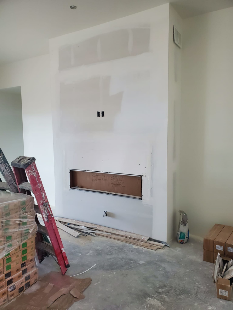 Fireplace framing and drywall installation in progress with construction materials by AV Handyman Services in Rio Rancho, NM.