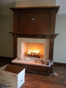A fireplace installation in progress with tools and materials on the floor by Infinite Fire Features in Colorado Springs, CO.