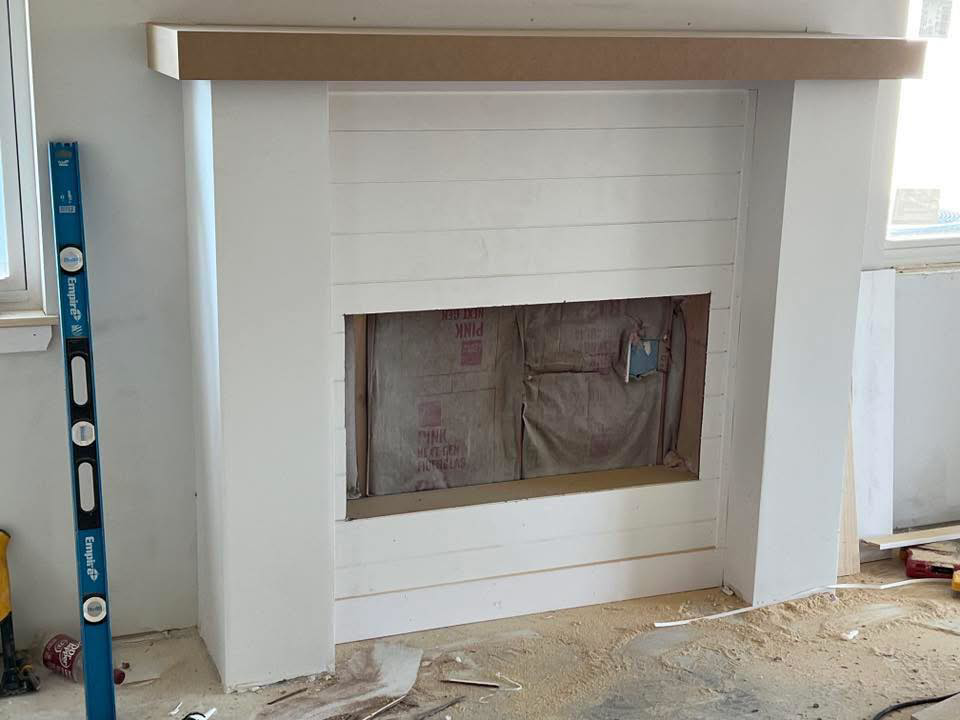 A fireplace mantel under construction with shiplap paneling by Blackbird Custom Carpentry in Kansas City, MO.