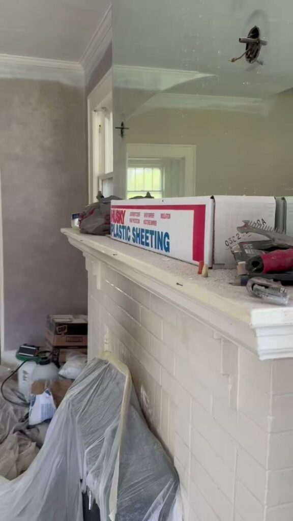 Fireplace mantel area covered with plastic sheeting during a renovation project by Contractor Kev LLC in Winston-Salem, NC
