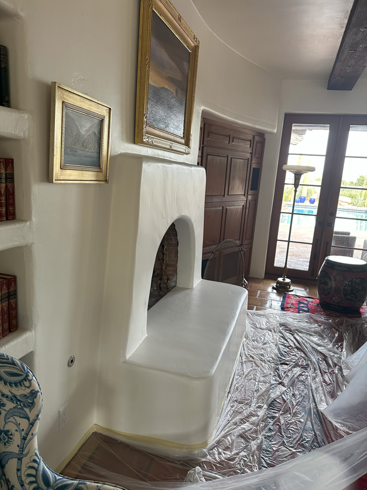 Fireplace area covered in plastic sheeting for painting preparation by Paint Co in Canyon Lake, CA
