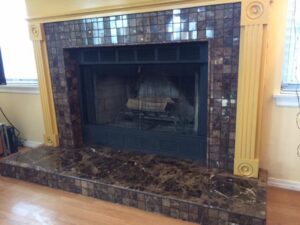 A renovated fireplace featuring a new tile surround and marble hearth installed by Pro Remodel LLC in St. Charles, MO.