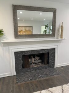A fireplace with a newly installed tile surround and white mantel by Infinite Creations Construction, LLC in Denver, CO