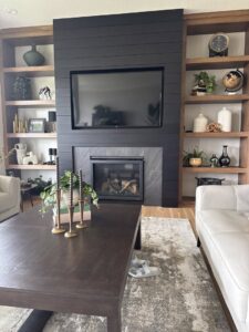 A living room featuring a modern fireplace, mounted television, and custom built-in shelves by Thimijan Custom Homes LLC in Rochester, MN