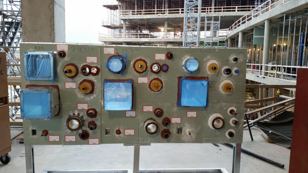 A firestopping sample board demonstrating fire-rated seals on a construction site by Bartkowski Life Safety, Corp. in Raleigh, NC.