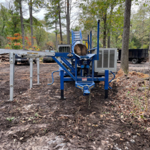 A firewood processor machine with a log, used for wood processing by Haslam Tree Service Inc. in Feura Bush, NY.