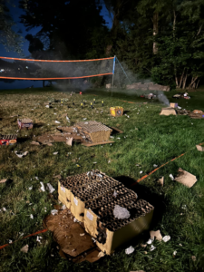 A large grassy area covered in spent fireworks debris and boxes, ready for cleanup by Custom Roll-Off Solutions in Des Moines, IA.