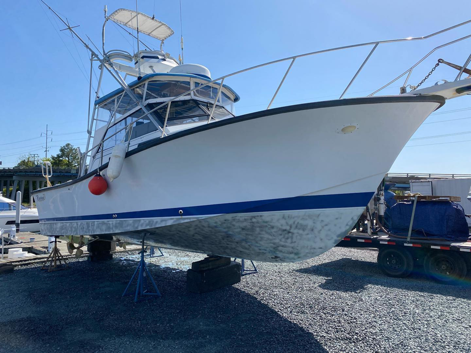 A fishing boat hull showing fouling before eco-blasting cleaning by Beach Eco Blasting in Virginia Beach, VA.