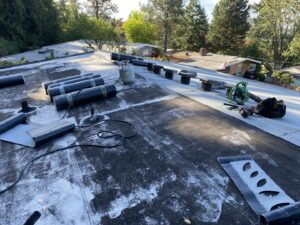 Flat roof installation with rolled roofing materials and tools by Sunny's roofing LLC in Denver, CO.