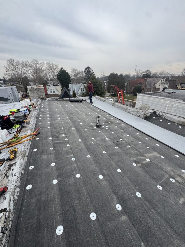 Insulation boards being installed on a flat roof during a project by RHI Construction Inc in Philadelphia, PA.