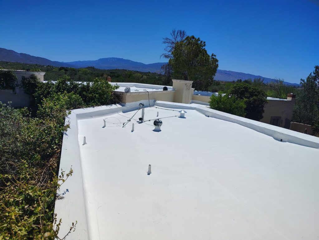 A large flat roof with a fresh white coating applied by Mayitos roofing LLC in Tucson, AZ.