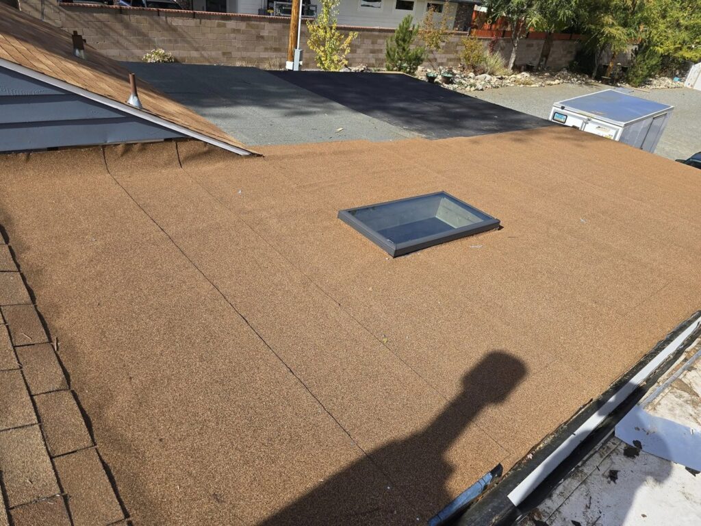A newly installed or repaired flat roof with a skylight, demonstrating roofing services by Tillman's Handyman Service in Sparks, NV.