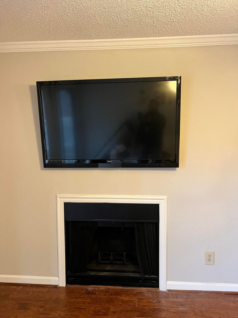 A flat-screen television professionally mounted above a fireplace by Gardner Home Services in Pleasant Grove, AL.