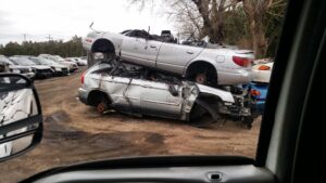 A white flatbed tow truck parked at the salvage yard of First Class Auto Salvage Inc. in Trenton, NJ