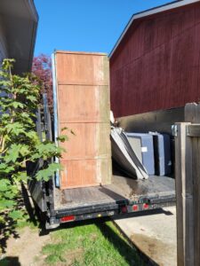 A flatbed trailer loaded with large wooden panels and other items, ready for hauling by Primetime Hauling and Junk Removal in Spokane, WA.