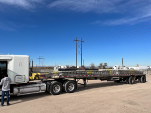 A flatbed truck loaded with construction materials ready for delivery by Arco Concrete Inc in Fort Lupton, CO
