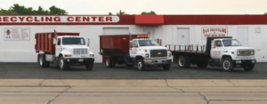 A fleet of SS ROLL OFF Dumpsters trucks and dumpsters parked at their recycling center in Rockford, IL.